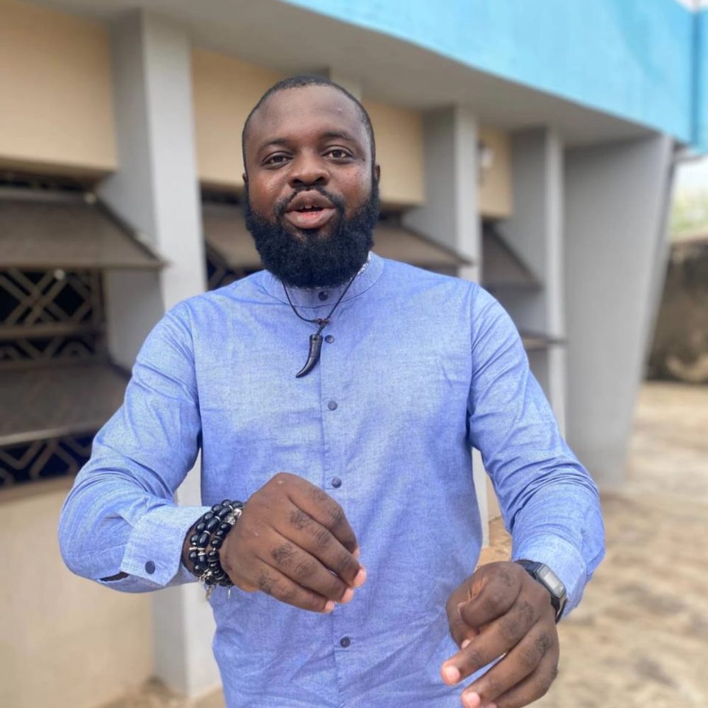 Femi Fragile in a blue shirt, mid-conversation